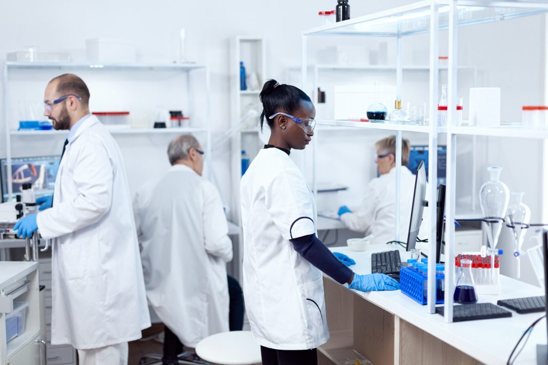 African scientist and her colleagues doing experiments