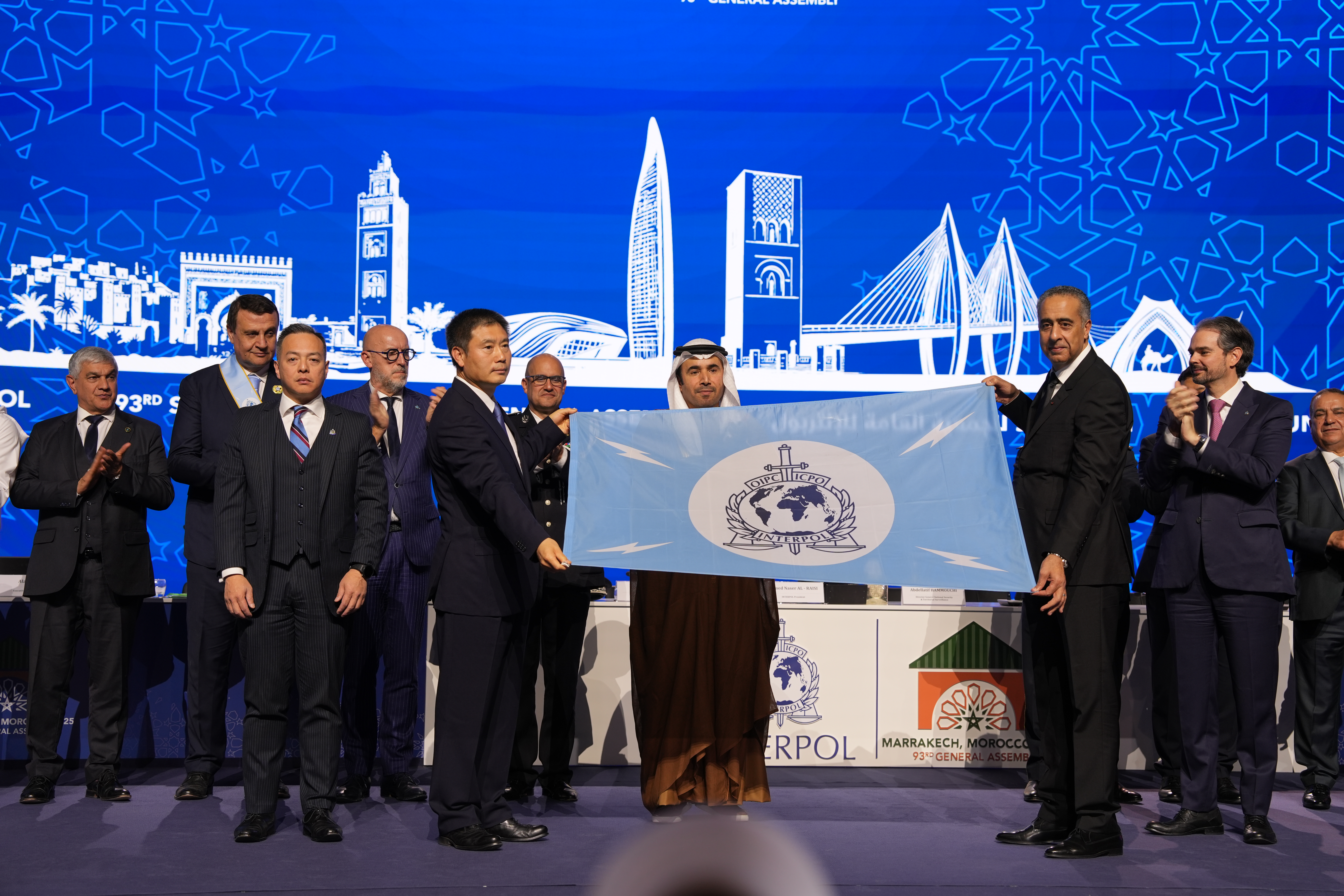 The Vice Minister of Public Security of the People's Republic of China, Mr Xu Datong (second left, front row), accompanied by the Hong Kong SAR's Commissioner of Police, Mr Chow Yat-ming (first left, front row), receives the INTERPOL flag at the closing ceremony during the 93rd INTERPOL General Assembly in Morocco last November, symbolising that the next General Assembly will be held in Hong Kong